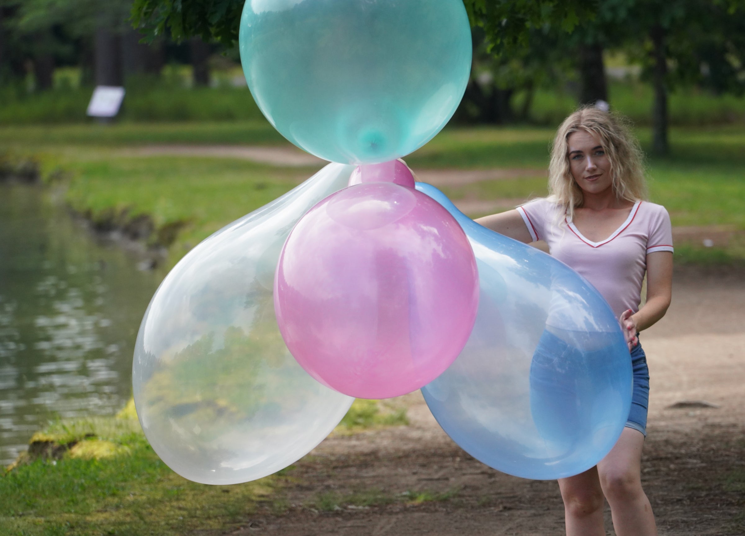 Juicy Alchemy holding a 4, big, 24 inch crystal colored balloons